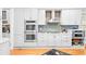 A modern kitchen with stainless steel dual ovens, white cabinets, and a brick backsplash, perfect for cooking gourmet meals at 1974 Mason Mill Rd, Decatur, GA 30033