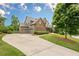 Spacious driveway leading to a home with well-manicured lawn and mature trees at 6345 Sterling Shores Dr, Cumming, GA 30041