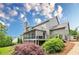 Back exterior view of a two-story home with a screened porch and beautiful landscaping at 6345 Sterling Shores Dr, Cumming, GA 30041