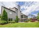 Rear exterior view of a two-story home with a finished outdoor space and landscaping at 6345 Sterling Shores Dr, Cumming, GA 30041