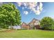 Charming two-story home with lush lawn, mature trees, and classic architectural details at 6345 Sterling Shores Dr, Cumming, GA 30041