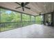 Spacious screened porch with tile flooring, ceiling fans, and views of the lush backyard and surrounding greenery at 6345 Sterling Shores Dr, Cumming, GA 30041