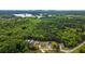Expansive aerial view showing multiple homes nestled among lush greenery and a tranquil lake at 6830 Heard Ln, Cumming, GA 30041