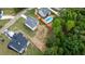 Aerial view of several homes, with one featuring a swimming pool, all nestled in a lush, green landscape at 6830 Heard Ln, Cumming, GA 30041