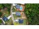Aerial view showcases a luxury home with a sparkling pool and lush landscaping, surrounded by mature trees at 6830 Heard Ln, Cumming, GA 30041