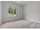 Bright bedroom with plush carpeting and a large window offering scenic views at 6830 Heard Ln, Cumming, GA 30041