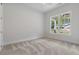 Well-lit bedroom with carpet and view from the large window at 6830 Heard Ln, Cumming, GA 30041