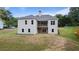 Rear exterior of the home showcasing a small upper deck and a large grassy yard sloping away from the house at 6830 Heard Ln, Cumming, GA 30041