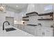 Modern kitchen featuring a gas range, marble countertops, subway tile backsplash and wooden floating shelves at 6830 Heard Ln, Cumming, GA 30041