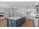Spacious kitchen with a large island, stainless steel appliances, and views of the living area with fireplace at 6830 Heard Ln, Cumming, GA 30041