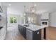 Open kitchen with large island, stainless steel appliances, and a view of the fireplace and backyard at 6830 Heard Ln, Cumming, GA 30041