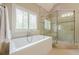 Bright bathroom featuring a soaking tub, frameless shower and plantation shutters at , Cumming, GA 30041