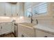Elegant kitchen boasts custom cabinets, marble countertops, a farmhouse sink, and stylish tile backsplash at , Cumming, GA 30041