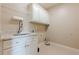 Well-equipped laundry room featuring a granite countertop, sink, and white cabinets for ample storage at , Cumming, GA 30041
