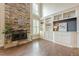 Cozy living room with a stone fireplace, built-in bookshelves, hardwood floors, and natural light at , Cumming, GA 30041