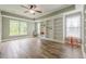Bright living room with large windows, wood floors, a ceiling fan, and built-in bookshelves at , Cumming, GA 30041