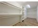 Spacious walk-in closet with built-in shelves and wooden floors for optimal organization and storage at , Cumming, GA 30041