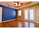 Bedroom with a blue accent wall, hardwood floors, and access to outdoor balcony at 35 Brooke Holw, Covington, GA 30016
