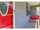 Relaxing front porch with a red swing, a red front door and neutral siding at 35 Brooke Holw, Covington, GA 30016