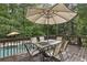 Outdoor deck featuring a dining table with an umbrella and views of the swimming pool at 905 Brooksglen Dr, Roswell, GA 30075