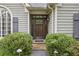 Close-up of a beautiful wood front door with sidelights and decorative shrubs at 905 Brooksglen Dr, Roswell, GA 30075