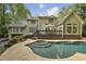 A backyard pool with hot tub and a deck are surrounded by trees at 905 Brooksglen Dr, Roswell, GA 30075