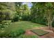 Expansive backyard with well-manicured lawn surrounded by mature trees, offering space for recreation and relaxation at 973 Peachtree Battle Ave, Atlanta, GA 30327