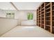 Open bonus room with custom wood shelving, natural light, and neutral carpet at 973 Peachtree Battle Ave, Atlanta, GA 30327