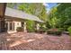 A classic brick patio with mature landscaping features an outdoor lounge area, perfect for relaxation and entertaining guests at 973 Peachtree Battle Ave, Atlanta, GA 30327