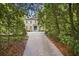 Traditional home with a manicured front lawn, tree-lined driveway and a distinctive blue front door at 973 Peachtree Battle Ave, Atlanta, GA 30327