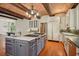 Spacious gourmet kitchen features brick ceiling, wood beams, stainless steel appliances and large island at 973 Peachtree Battle Ave, Atlanta, GA 30327