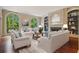 Bright living room featuring arched windows, built-in shelving, a fireplace, and comfortable seating at 973 Peachtree Battle Ave, Atlanta, GA 30327