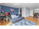 Living room with desk, hardwood floors, blue accent wall, and an open layout at 1421 Peachtree Ne St # 304, Atlanta, GA 30309