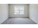 Neutral carpeted bedroom provides a serene atmosphere with its bright window and ample natural light at 2255 Bigwood Trl, Atlanta, GA 30349