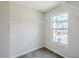 Carpeted walk-in closet with open white racks and shelving, bright window, and ample storage space at 2255 Bigwood Trl, Atlanta, GA 30349