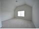 Bedroom featuring vaulted ceilings, carpeted floors, and a bright window at 2522 Bear Mountain St, Lithonia, GA 30058