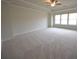 Spacious bedroom with large windows, plush carpet, and ceiling fan providing ample natural light at 2522 Bear Mountain St, Lithonia, GA 30058