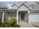 Inviting front porch with white columns and brick accents, leading to a gray front door at 2522 Bear Mountain St, Lithonia, GA 30058