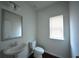 Half bathroom with a pedestal sink, a toilet, and a window at 2522 Bear Mountain St, Lithonia, GA 30058