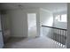 Second floor landing with carpet, white walls, dark railing, and light fixture at 2522 Bear Mountain St, Lithonia, GA 30058