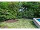 Expansive backyard features lush lawn, mature trees, and a sleek modern pool, perfect for relaxation and entertaining at 27 Maddox Ne Dr, Atlanta, GA 30309