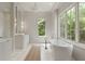 Bright bathroom with a soaking tub, large windows, and a decorative table at 27 Maddox Ne Dr, Atlanta, GA 30309