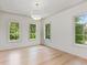 Bright bedroom features three large windows, hardwood flooring, and soft white walls at 27 Maddox Ne Dr, Atlanta, GA 30309