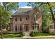 Elegant brick home featuring a landscaped front yard, large windows, and a classic architectural design at 27 Maddox Ne Dr, Atlanta, GA 30309