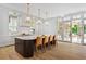 Bright kitchen with a large island with seating, marble counters, and views to the outdoor patio at 27 Maddox Ne Dr, Atlanta, GA 30309