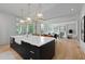 Large kitchen island with white marble counters, pendant lights and access to an adjacent Gathering room at 27 Maddox Ne Dr, Atlanta, GA 30309