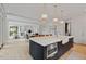Large kitchen island with white marble counters, pendant lights and access to an adjacent Gathering room at 27 Maddox Ne Dr, Atlanta, GA 30309