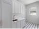 Bright laundry room features custom cabinets, marble countertop, stainless steel sink, and geometric tile floor at 27 Maddox Ne Dr, Atlanta, GA 30309