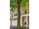 Inviting brick townhome features an attached garage, an arched entryway, and a tree-lined front yard at 576 Fraser Se St, Atlanta, GA 30312