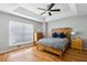Spacious main bedroom with a tray ceiling, hardwood floors, and a wooden headboard at 576 Fraser Se St, Atlanta, GA 30312